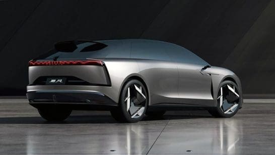 Rear three-quarter view of a silver futuristic concept car on a reflective tile surface with seamless design.